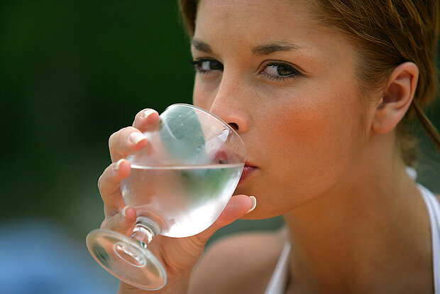 Abbildung einer Frau, die ein Glas Wasser trinkt